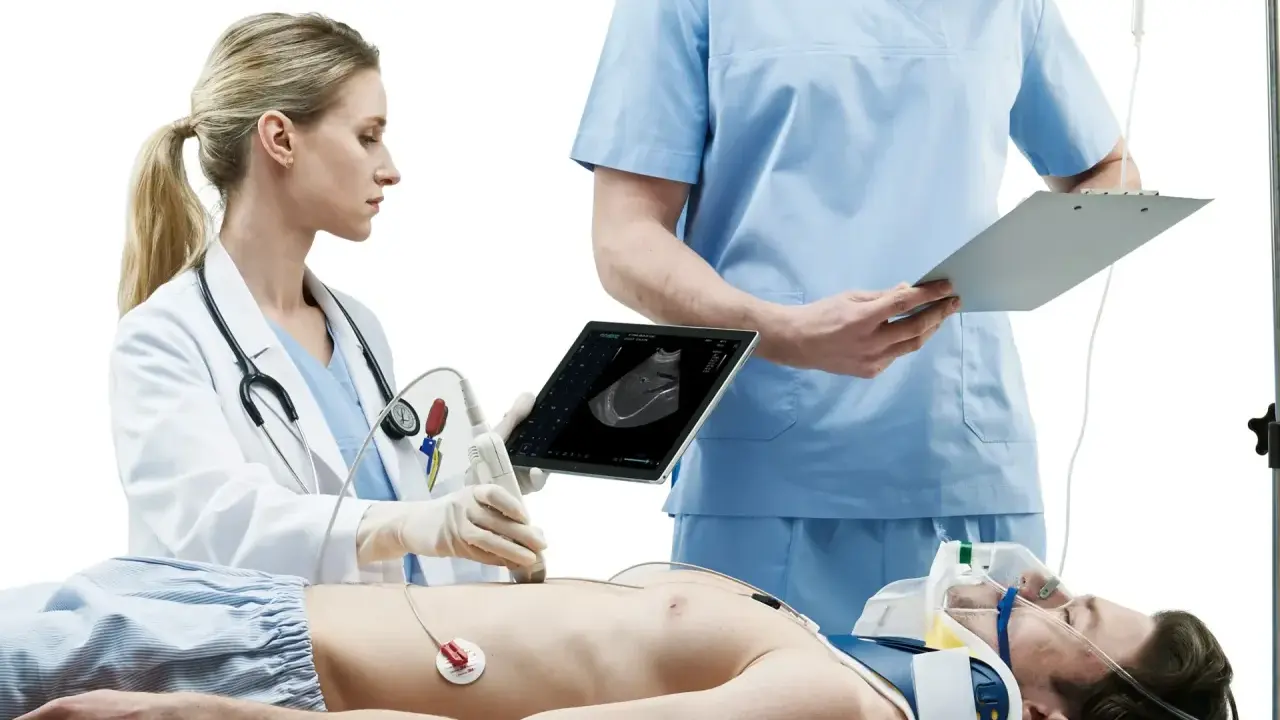 Lekarka wykonuje USG pacjenta, który leży na stole. Obok stoi lekarz z notatkami. Szybka diagnostyka to klucz do ratowania życia.