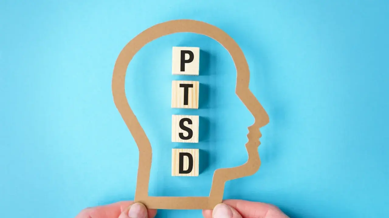 Klocki z literami P, T, S, D układają się w napis PTSD wewnątrz sylwetki głowy. Symbolizuje to wpływ zespołu stresu pourazowego, znanego w ICD-10.