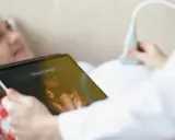 Kobieta na tablecie widzi obraz z USG. To badanie ultrasonograficzne, które pokazuje rozwój dziecka.