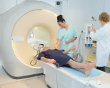 Pacjent na stole do rezonansu magnetycznego, przygotowywany przez pielęgniarki. Szybkie wyniki badań to klucz do diagnozy.