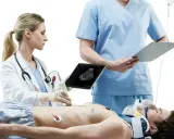 Lekarka wykonuje USG pacjenta, który leży na stole. Obok stoi lekarz z notatkami. Szybka diagnostyka to klucz do ratowania życia.