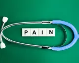Stetoskop i kostki z literami "PAIN" symbolizują ból, który może być klasyfikowany według ICD-10.