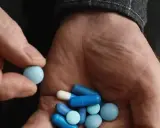Dłoń trzyma garść niebieskich i białych tabletek. Czy Citaxin to psychotrop?