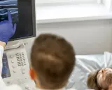 Lekarz wykonuje badanie doppler tętnic mózgowych, analizując obraz na monitorze USG.