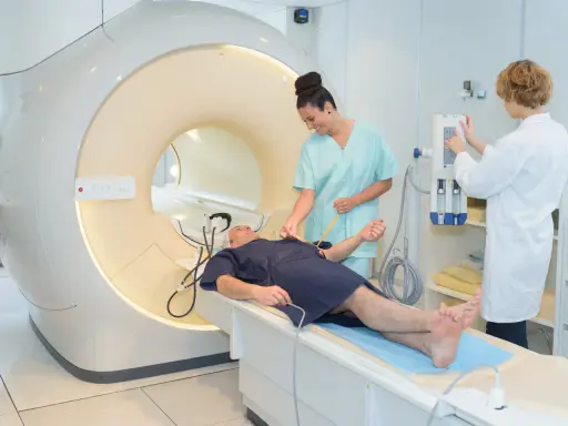Pacjent na stole do rezonansu magnetycznego, przygotowywany przez pielęgniarki. Szybkie wyniki badań to klucz do diagnozy.