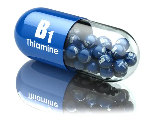 Duża, niebieska kapsułka z napisem "B1 Thiamine" wypełniona mniejszymi, niebieskimi kulkami z tym samym napisem. To jakby wizualizacja działania benfogamma forte.