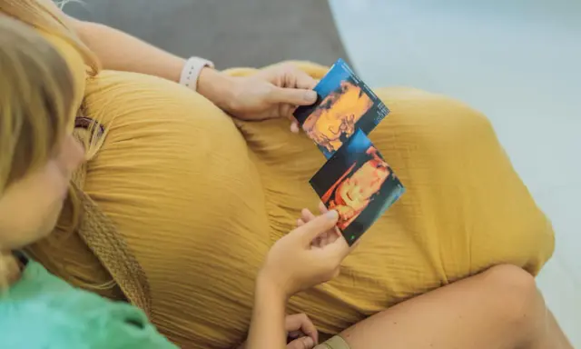 Dziecko na zdjęciach usg 3d, które trzymają mama i starsze rodzeństwo.