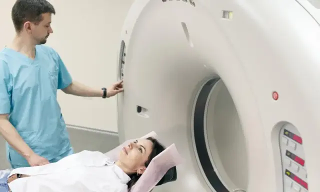Pacjentka leży na stole do rezonansu, a technik przygotowuje aparat do badania. Rezonans całego organizmu co wykrywa? To zaawansowana diagnostyka obrazowa.