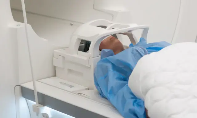 Pacjent leży w aparacie do rezonansu magnetycznego. Badanie, takie jak rezonans magnetyczny barku, trwa zazwyczaj od 30 do 60 minut.