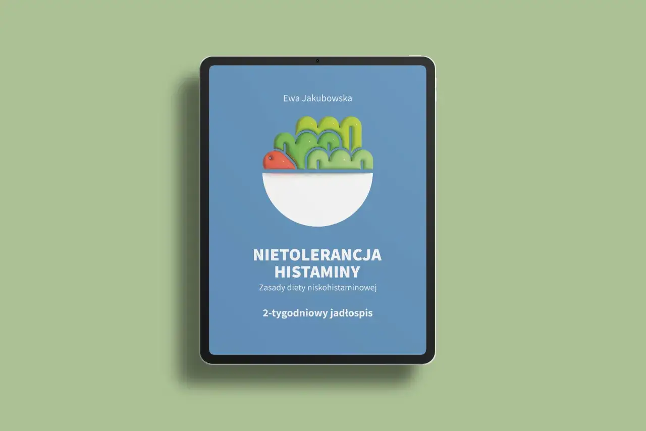 Na ekranie tabletu widnieje okładka książki "Nietolerancja histaminy. Zasady diety niskohistaminowej. 2-tygodniowy jadłospis" Ewy Jakubowskiej, prezentująca stylizowaną miskę z warzywami.