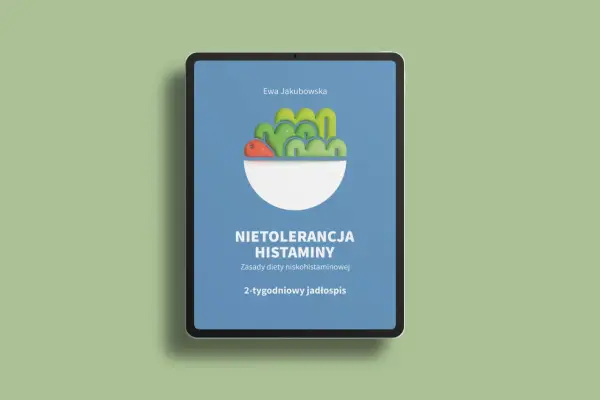 Na ekranie tabletu widnieje okładka książki "Nietolerancja histaminy. Zasady diety niskohistaminowej. 2-tygodniowy jadłospis" Ewy Jakubowskiej, prezentująca stylizowaną miskę z warzywami.